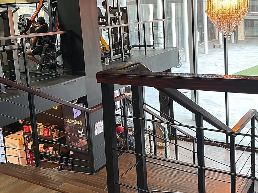 Escalera con candelabro y vista al gimnasio