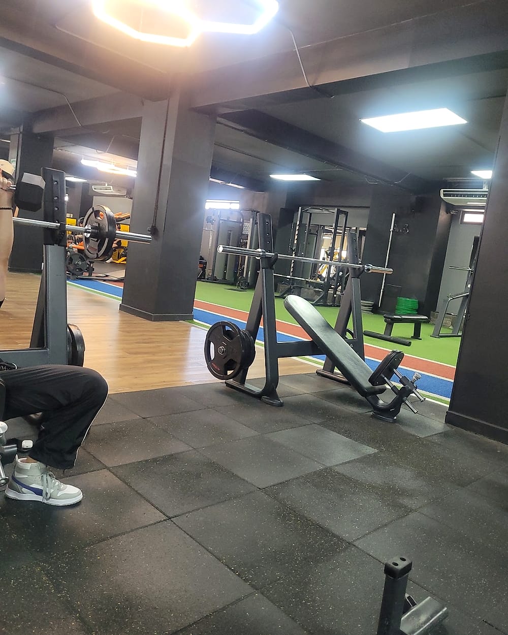 Área de pesas libres con bancos y discos en Lux Sport Clubs